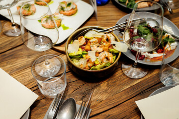 Salad with grilled shrimps and parmesan cheese flakes on the restaurant table.