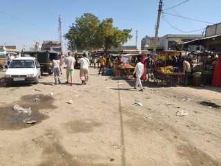 Marché local dans un village pauvre indien, plein de stands de vente de nourriture, pollution,...