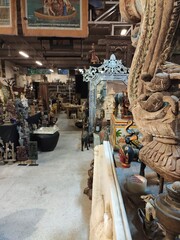 Visite d'un grand magasin de vente d'antiquité, d'objets historiques, de beaux arts ou oeuvres, de pièces de luxe, de toutes sortes de bricoles asiatiques ou de pays émergents, indien ou hindu, bois - obrazy, fototapety, plakaty