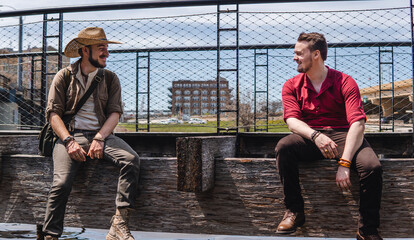 men sitting next to eachother on bench