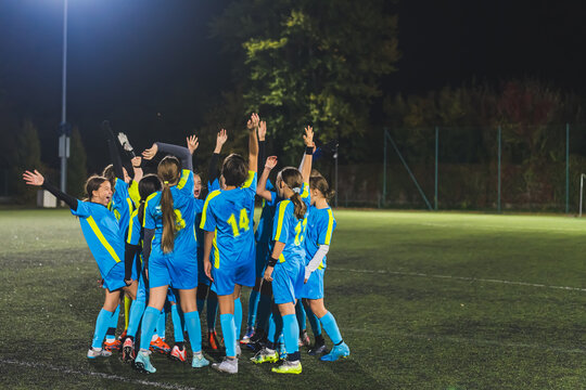 teenage girls football team preparing for match and encouraging each other, blue uniforms, active and sport life. High quality photo