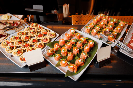 The salmon rolls are placed on square plates lined with banana leaves for an aesthetic presentation