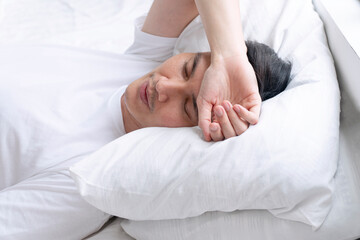 Tired asian handsome man sleeping peaceful on white pillow comfortable in morning at apartment...