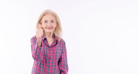 Positive healthy elderly woman showing thumbs up success looking at camera empty copy space over isolated white background. Cheerful friendly 70s retirement holding thumbs up emotions wisdom life.