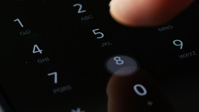 close up finger dialing pin or phone number on digital keyboard screen