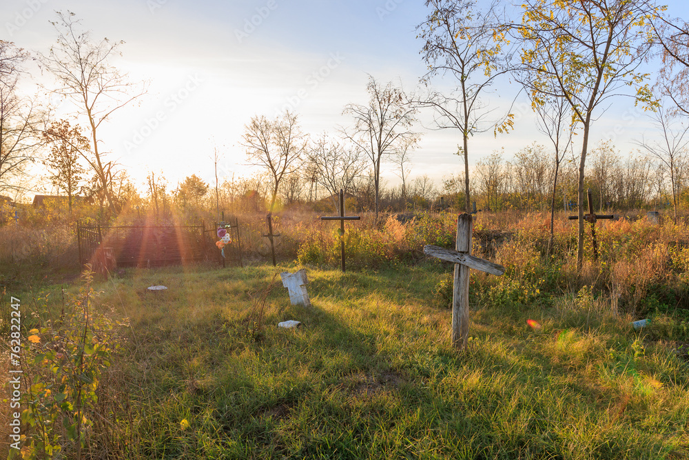 Wall mural a cemetery with a cross and a grave marker