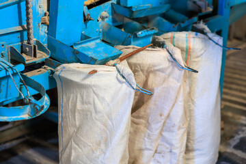 A blue machine with three white bags hanging from it