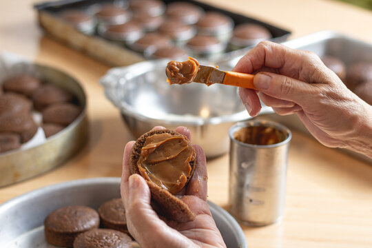 Recheando grande quantidade de p&atilde;es de mel rec&eacute;m cozidos artesanalmente com muito doce de leite 