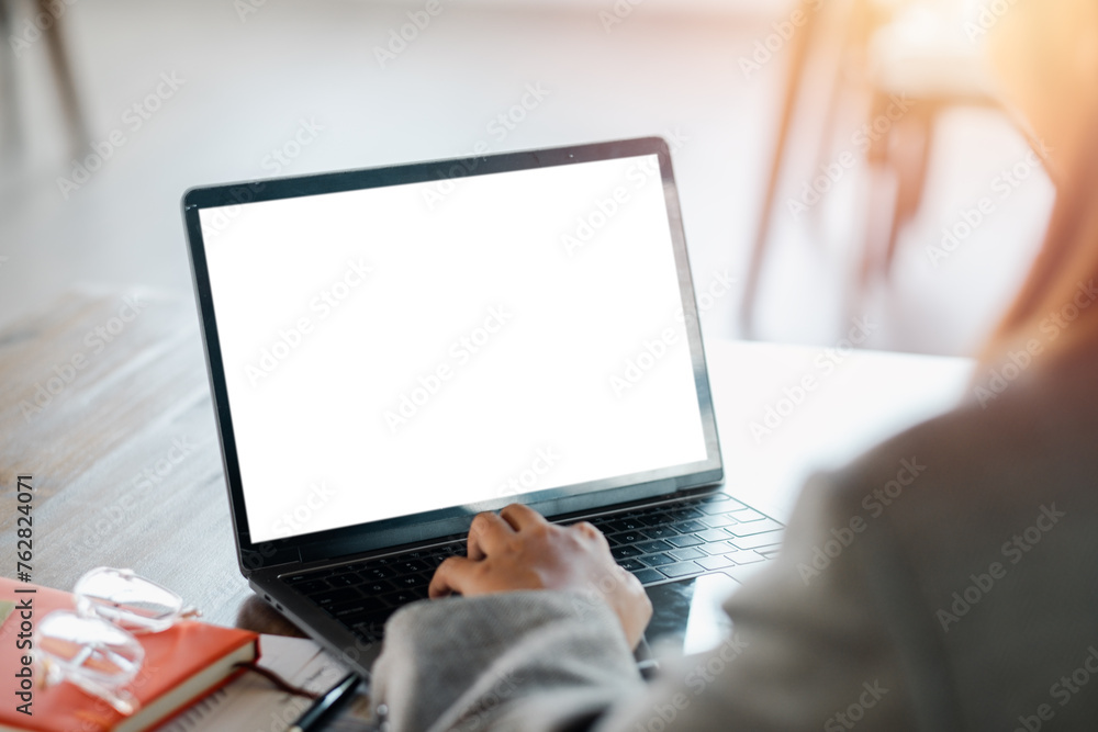 Poster close-up back view of a business woman working in the office typing, looking at the screen. office w