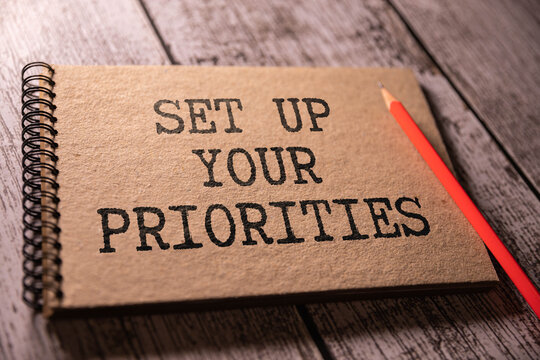 SET UP YOUR PRIORITIES text on a clipboard on wooden background