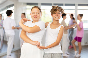 Girl dances Latin dance with male teenager partner during choreography lesson. Group training and...