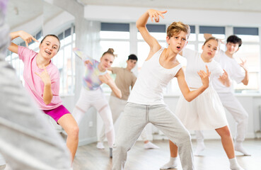 Fototapeta premium Group of teenagers learn to dance hip-hop and other modern dances in a spacious dance studio
