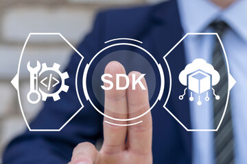 Business man using virtual touchscreen presses abbreviation: SDK. Concept of SDK Software...