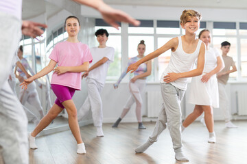 Obraz premium Group of boys and girls rehearsing jazz funk dance in studio