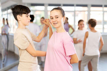 Pair of teen girl and guy enjoying of waltz dance in choreo class. Exciting hobby, active...