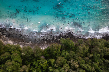 Ocean waves meet the rainforest at the turquoise coast of Weh island, Sumatra, Indonesia