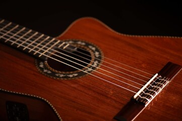 Classical Spanish flamenco guitar close up, dramatically lit isolated on black background with copy...