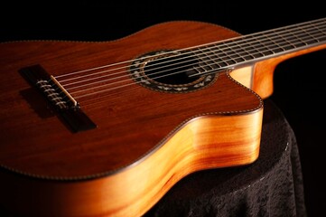 Fototapeta premium Classical Spanish flamenco guitar close up, dramatically lit isolated on black background with copy space.