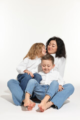 Little children with their mother sitting together on white background