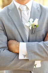 Groom in grey suit with pilot propeller airplane cufflink orchid boutonniere 