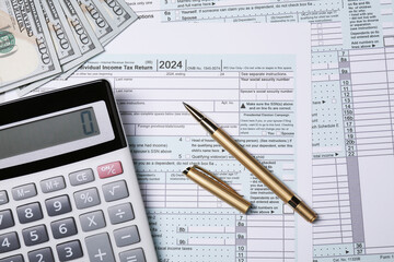 Tax return forms, pen, calculator and dollar banknotes on table, top view