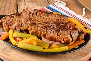 roast beef with seasonings and sliced ​​barbecue salad served on plate on wooden table