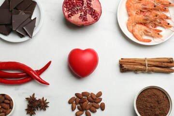 Natural aphrodisiac. Different products and heart model on white marble table, flat lay