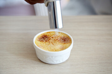 Torch Cooking Sugar on Creme Brulee