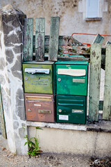 Green and Brown Mailboxes set in Broken Old Fence