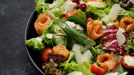 Fresh salmon salad with Parmesan cheese, tomatoes, and mixed greens