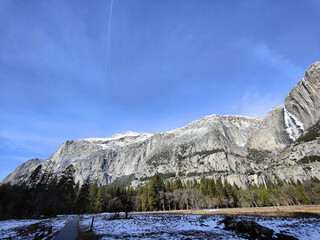 Fototapeta premium Winter's Patchwork at Yosemite: The Diverse Landscape of Snow, Meadow, and Majestic Peaks in the National Park of the United States
