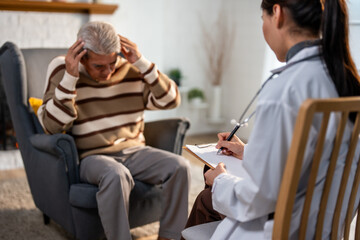 Fototapeta na wymiar Asian caregiver nurse examine and listen to senior man patient at home. 