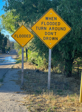 Flooded and when flooded turn around don't drown signs on the side of the road.