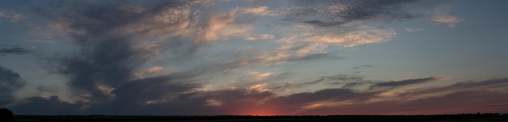 Naklejka na ściany i meble Landscape at sunset. Tragic gloomy sky. Panorama. Crimson twilight.