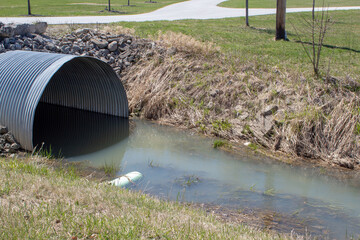 A water ditch with a riveted corrugated steel culvert.
