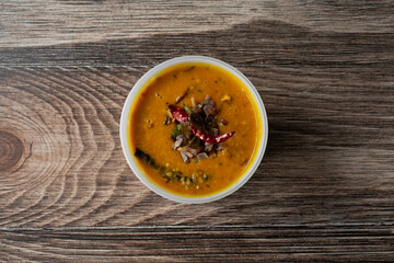 A top down view of a plastic container of dhal butter fry.