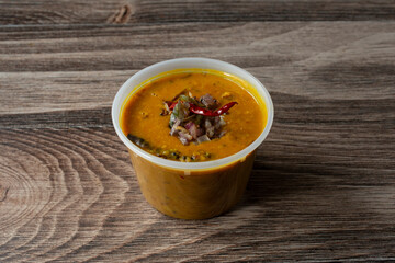 A view of a plastic container of dhal butter fry.