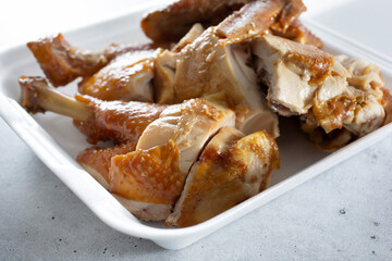 A view of a soy sauce marinated half chicken in a container.