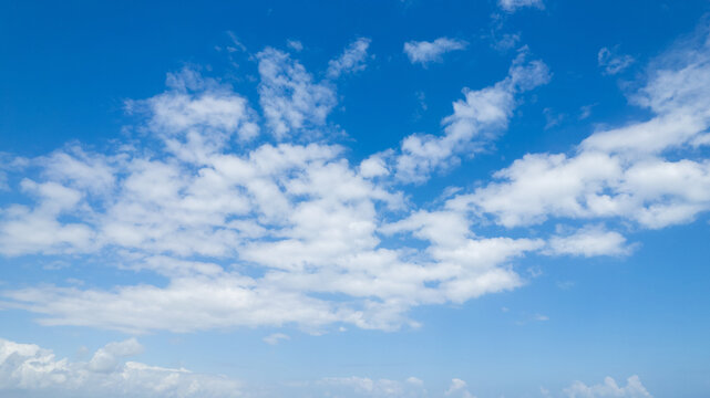 Serene blue sky with soft white clouds, ideal for background with ample space for text, Earth day concept