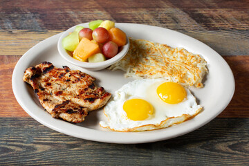 A view of a plate of chicken breast and eggs.