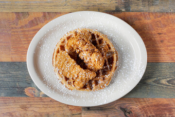 A top down view of a plate of chicken and waffles.