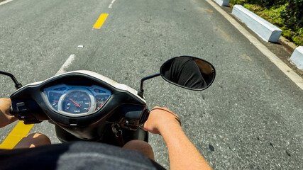 Rider's perspective of a scooter dashboard and asphalt road, capturing the essence of a sunny day...