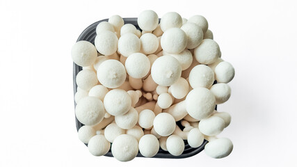 Fresh white shimeji mushrooms in a black bowl with a bright, clean background - ideal for food and culinary concepts