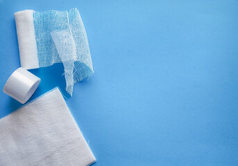 Medical gauze and bandage with copy space on a blue background, concept of healthcare and first aid
