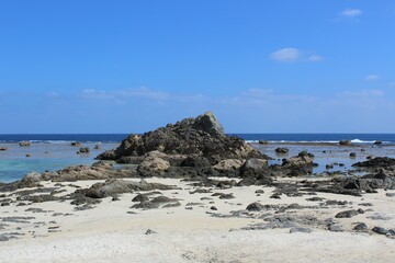 Fototapeta na wymiar Rocky and sandy beach, lagoon are protected by the coral reefs from rough waves