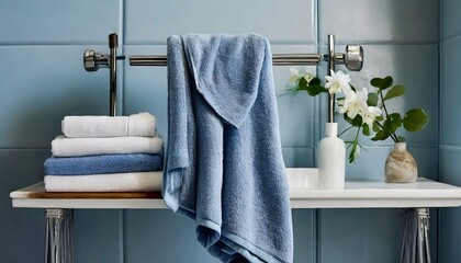 towels in a bathroom.a series of lifestyle images showcasing the cotton bath towel in blue  illustrating its versatility and style in various bathroom environments. Capture the towel draped over a to