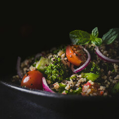 healthy Couscous salad vegetarian against a dark background fitness food