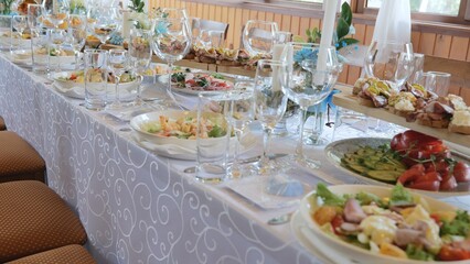A beautiful festive table covered with a variety of food. Food and drinks on the festive table in the restaurant on birthdays, weddings. Beautifully decorated banquet table with appetizers.
