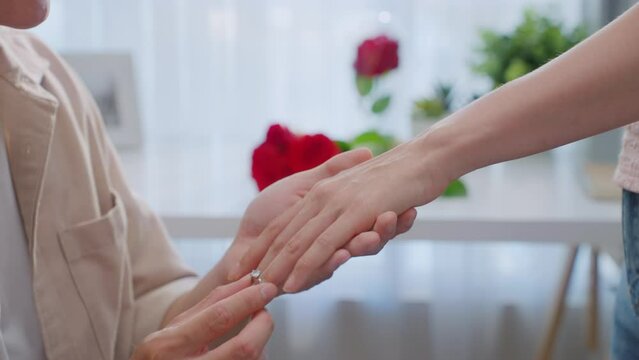 Close up of young man making surprise proposal of marriage to girlfriend. 