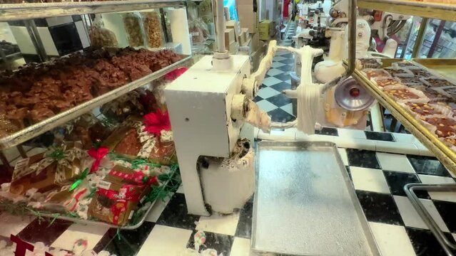 Up close static view of salt water toffee machine in candy store with chocolate near by